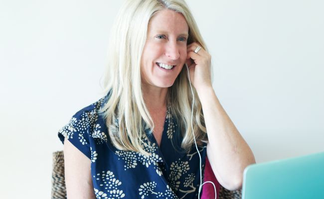 Tanya Mark putting in headphones while coaching a digital group workshop on her laptop.